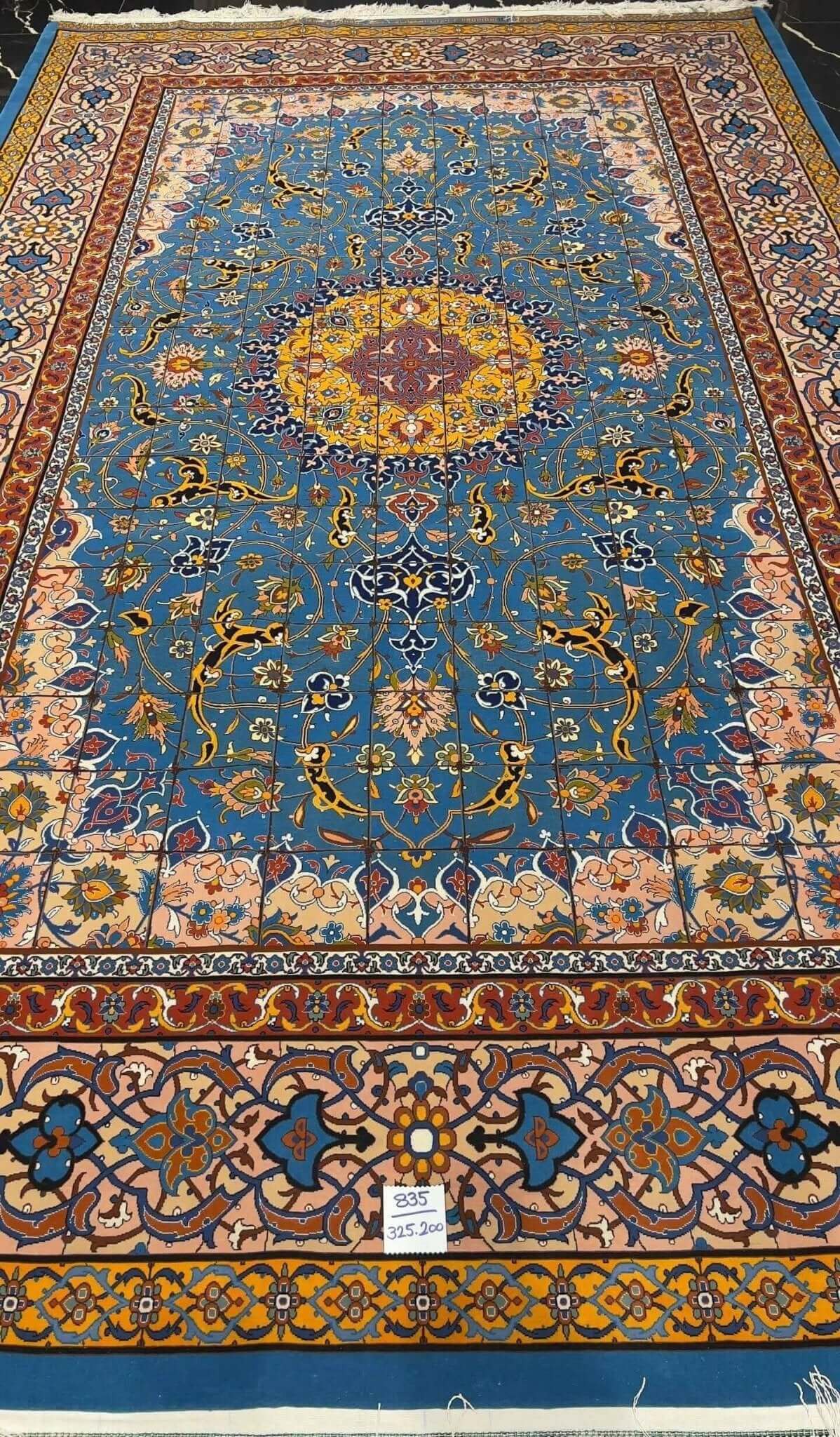 "Detailed view of the Persian rug's floral border design, highlighting the craftsmanship of Master Haghighie."